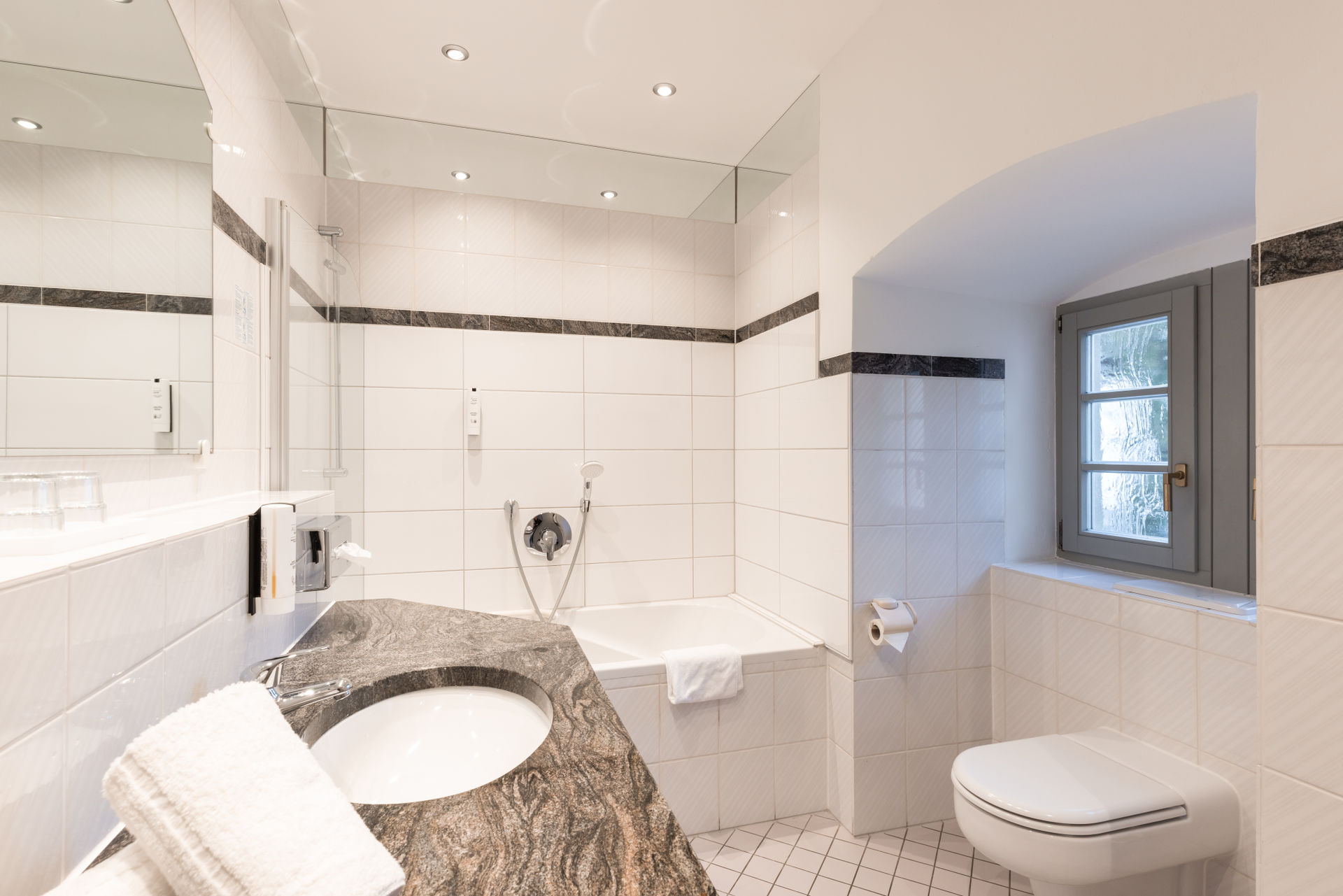 Badezimmer mit Wanne und Naturstein-Waschtisch