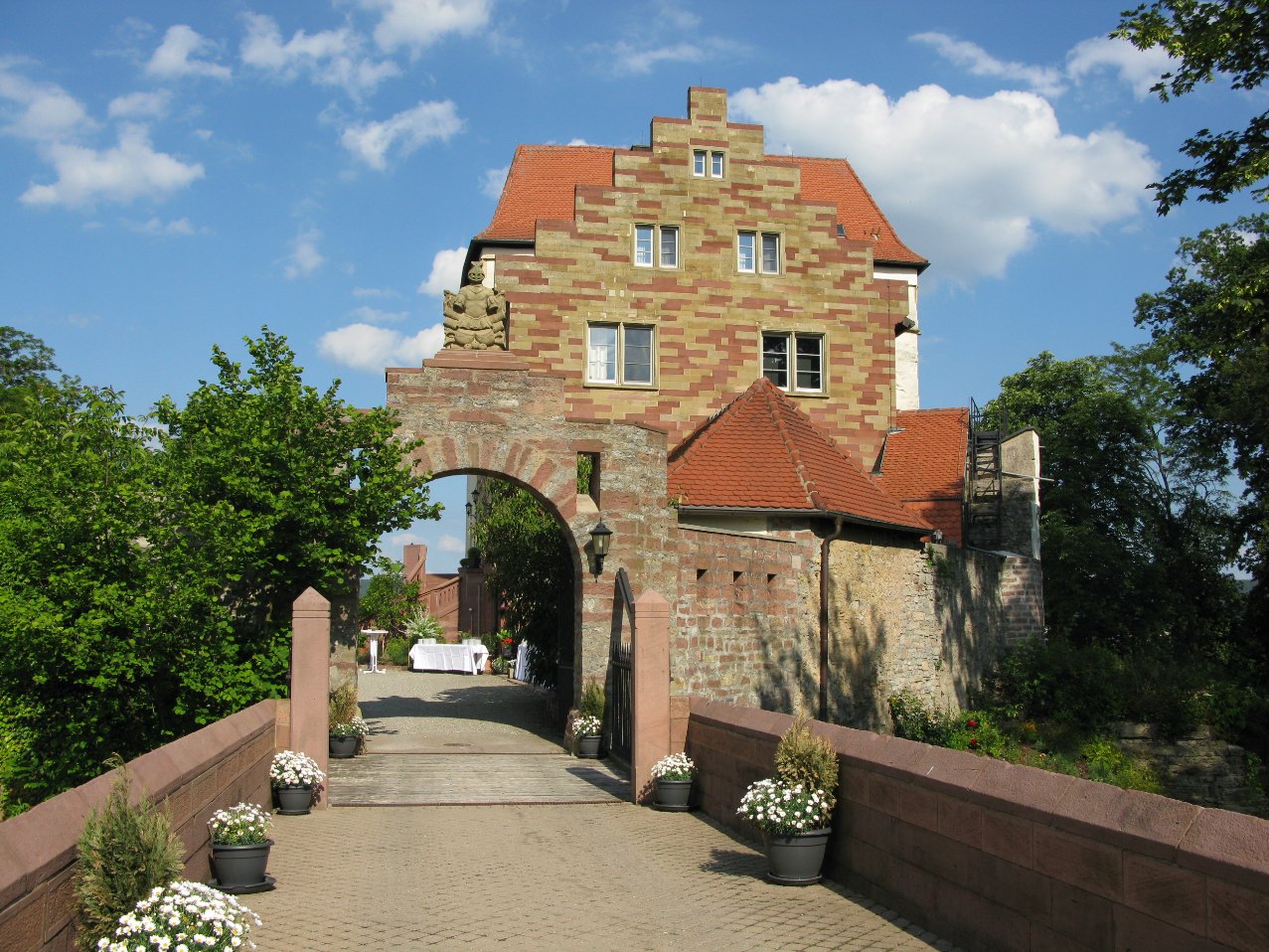 Torbogen und Steinbrücke mit Blumenschmuck